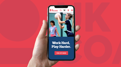 UK coaching website on a phone being held